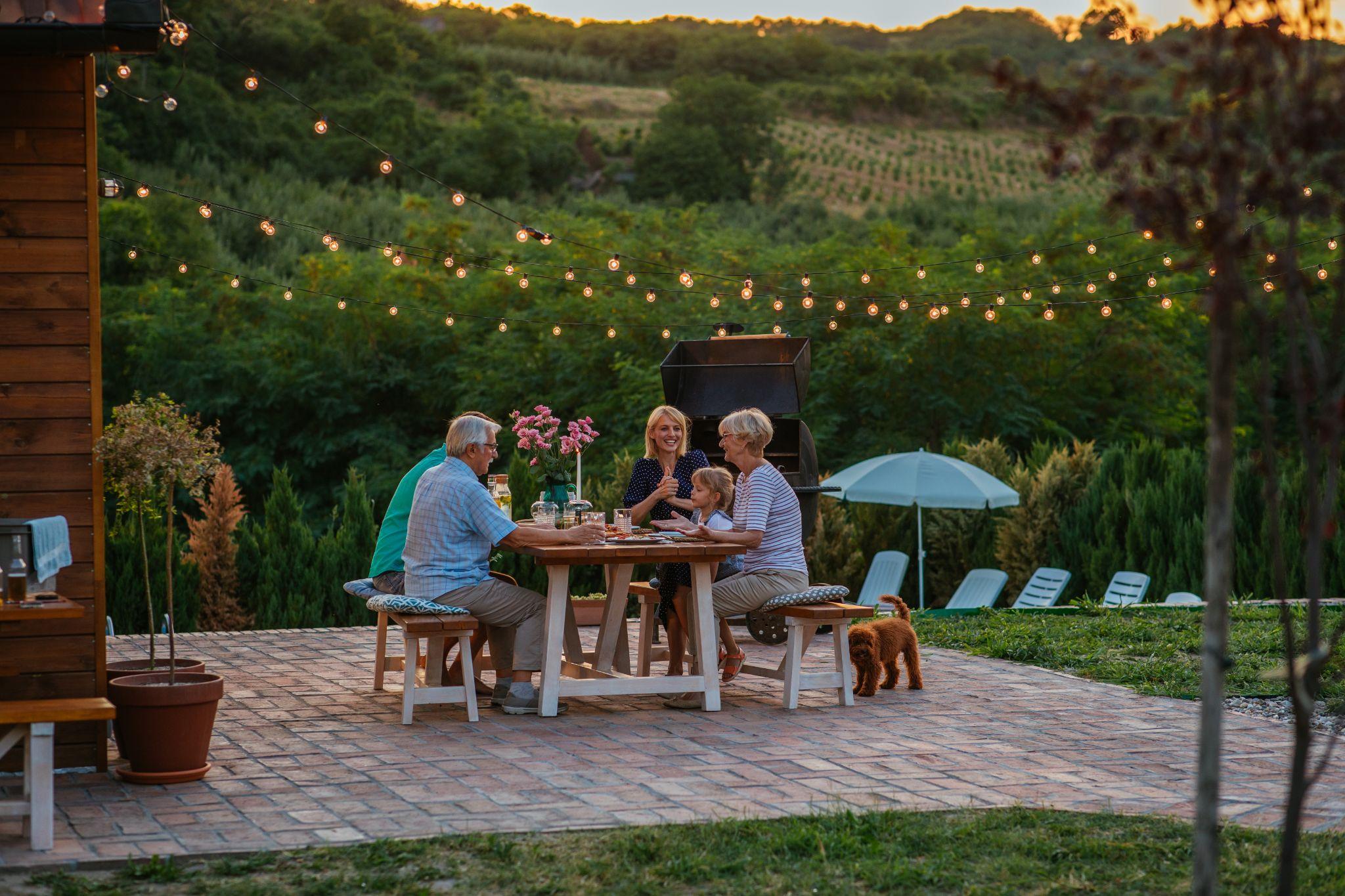 Family dining outside a log home